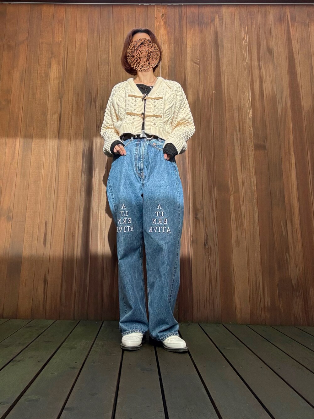 ホワイト系のカーディガン/ボレロ、ブラック系のTシャツ/カットソー、ブルー系のデニムパンツを着用したレディースの秋コーディネートの3枚目の写真