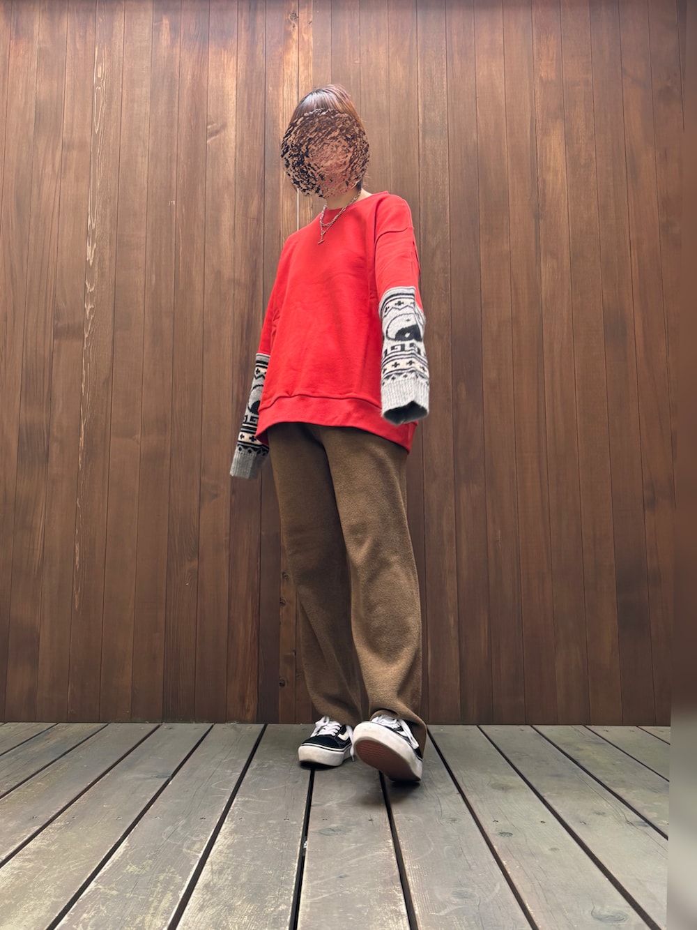 レッド系のスウェット、ブラウン系のパンツを着用したレディースの冬コーディネートの2枚目の写真