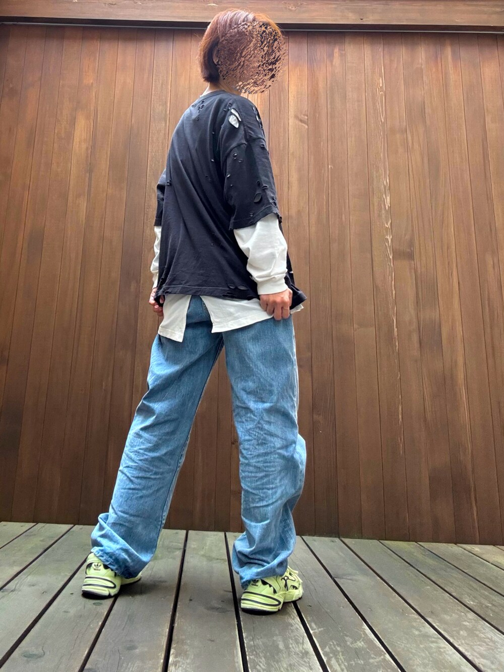 ブルー系のデニムパンツ、ブラック系のトップスを着用したレディースの秋コーディネートの3枚目の写真