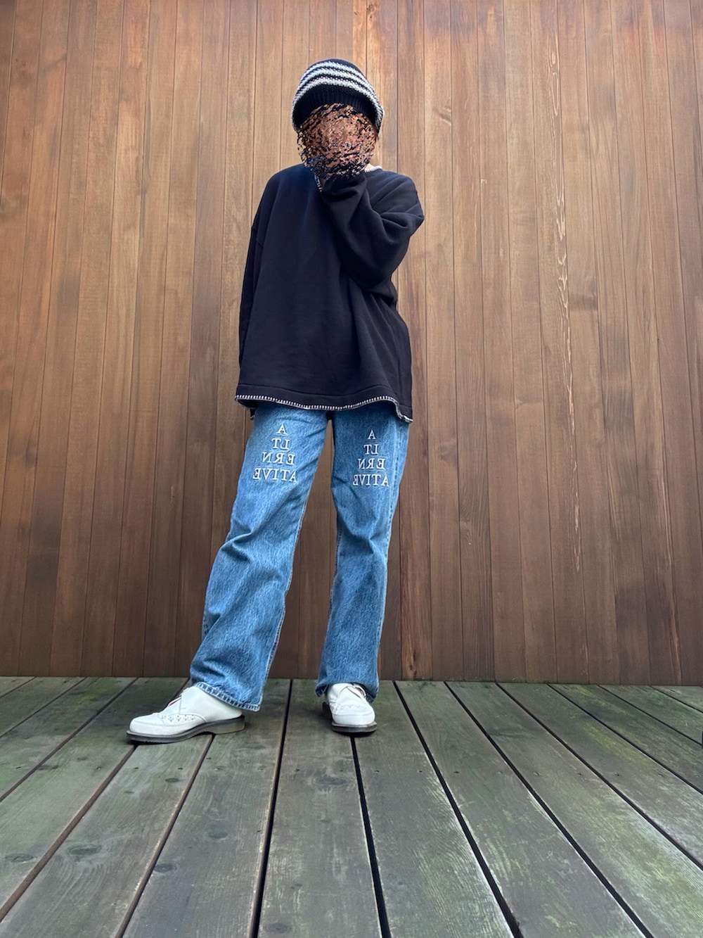 ブラック系のTシャツ/カットソー、ブルー系のデニムパンツ、ブラック系のニットキャップ/ビーニーを着用したレディースの秋コーディネートの4枚目の写真