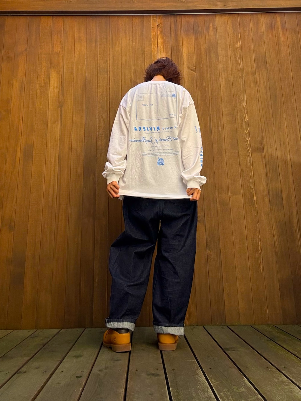 ホワイト系のトップス、ブルー系のデニムパンツ、ベージュ系のスニーカーを着用したレディースの秋コーディネートの3枚目の写真