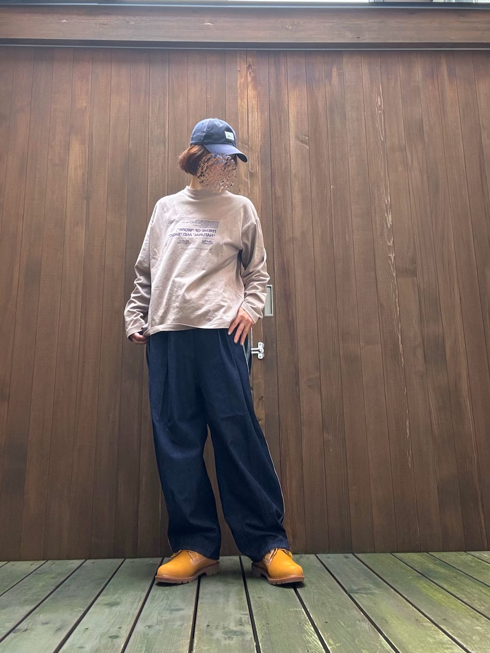 ブルー系のデニムパンツ、ベージュ系のスニーカー、ブラウン系のトップスを着用したレディースの秋コーディネートの3枚目の写真