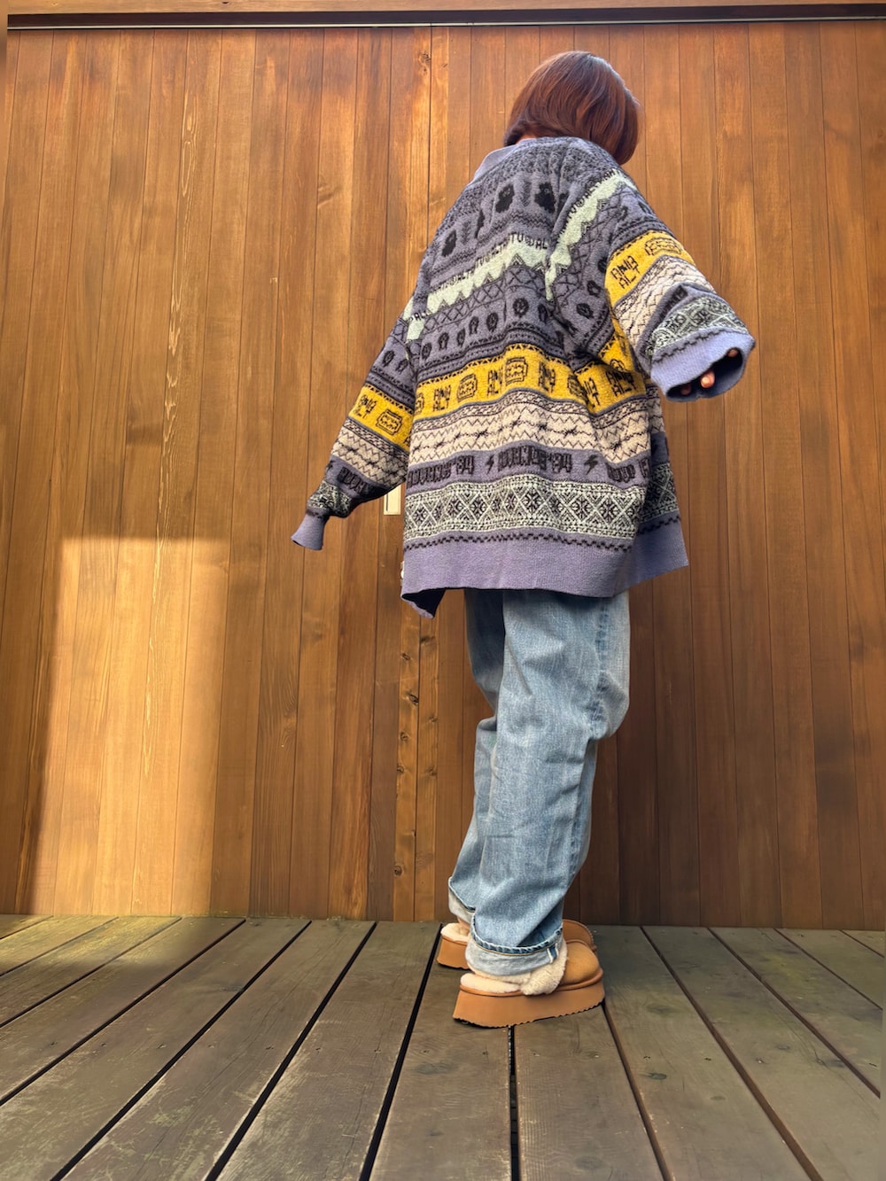 パープル系のカーディガン/ボレロ、ブラック系のキャミソール、ブルー系のデニムパンツを着用したレディースの秋コーディネートの3枚目の写真