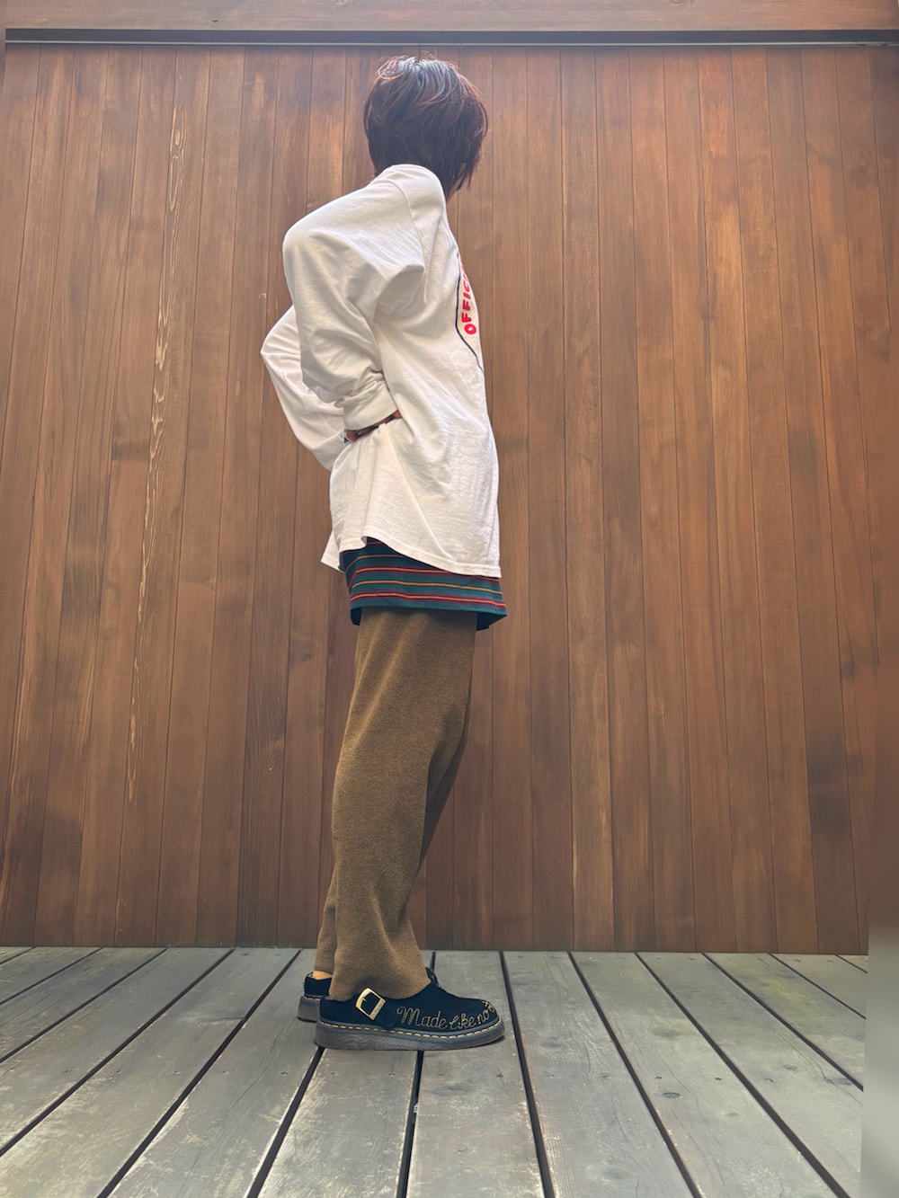 ブラウン系のパンツ、グリーン系のスカート、ホワイト系のTシャツ/カットソーを着用したレディースの春コーディネートの2枚目の写真