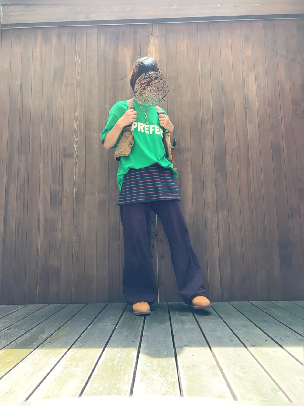 グリーン系のTシャツ/カットソー、ブラウン系のベスト、グリーン系のスカートを着用したレディースの夏コーディネートの2枚目の写真