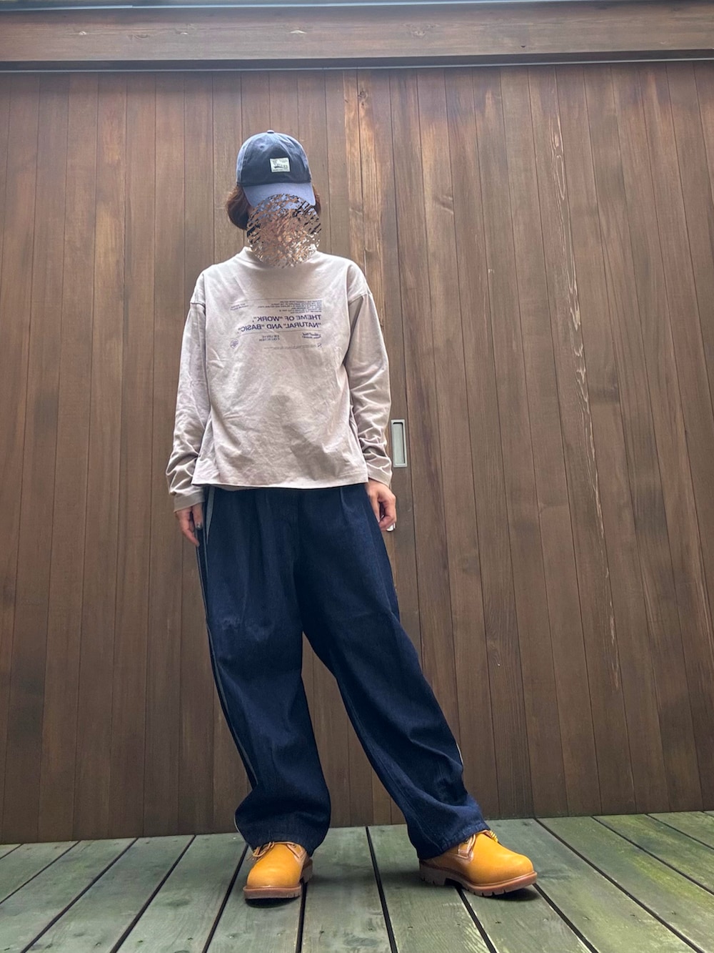 ブルー系のデニムパンツ、ベージュ系のスニーカー、ブラウン系のトップスを着用したレディースの秋コーディネートの2枚目の写真