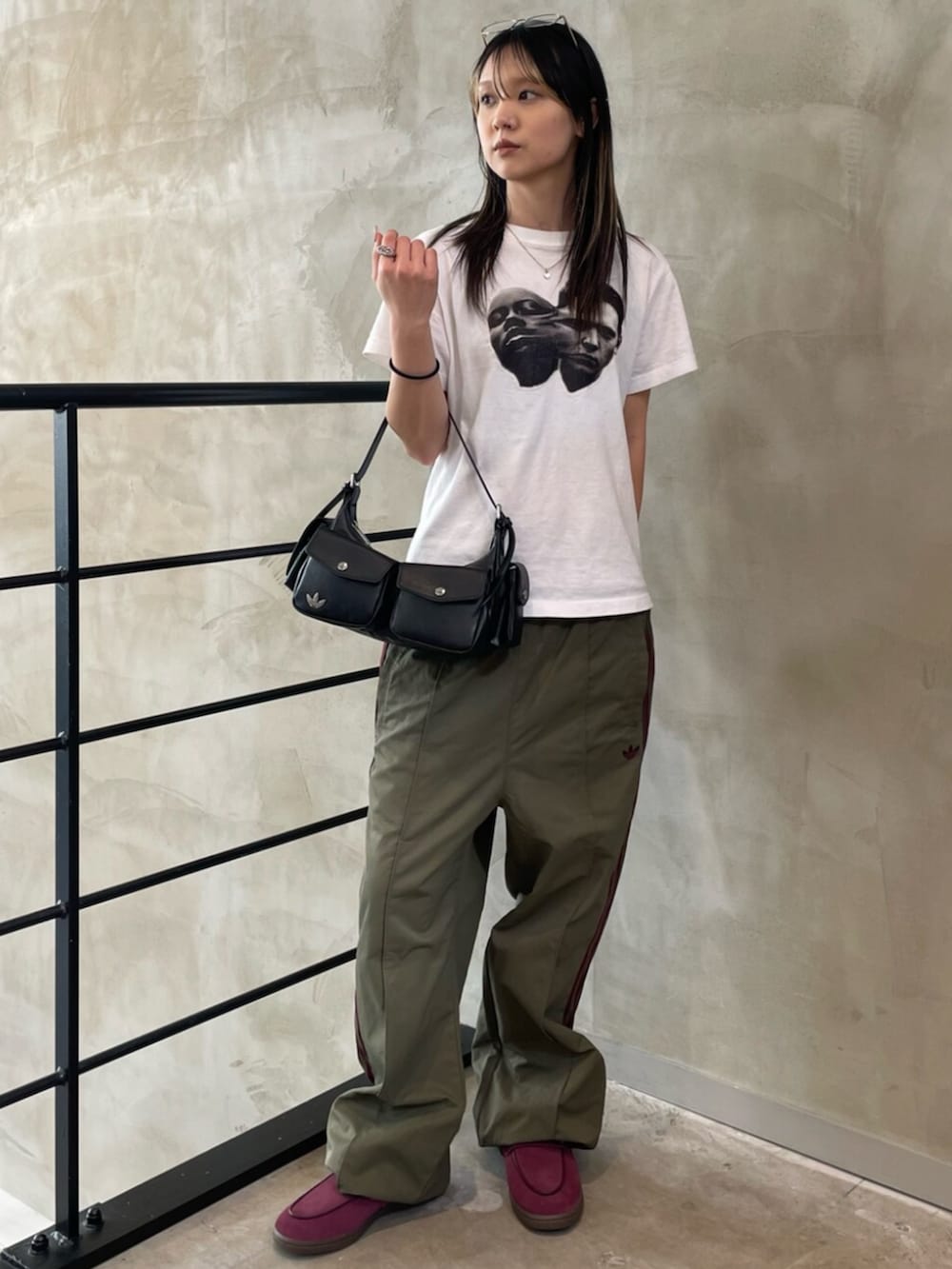 ブラック系のショルダーバッグ、レッド系のスニーカー、グリーン系のその他パンツを着用したレディースの春コーディネートの3枚目の写真