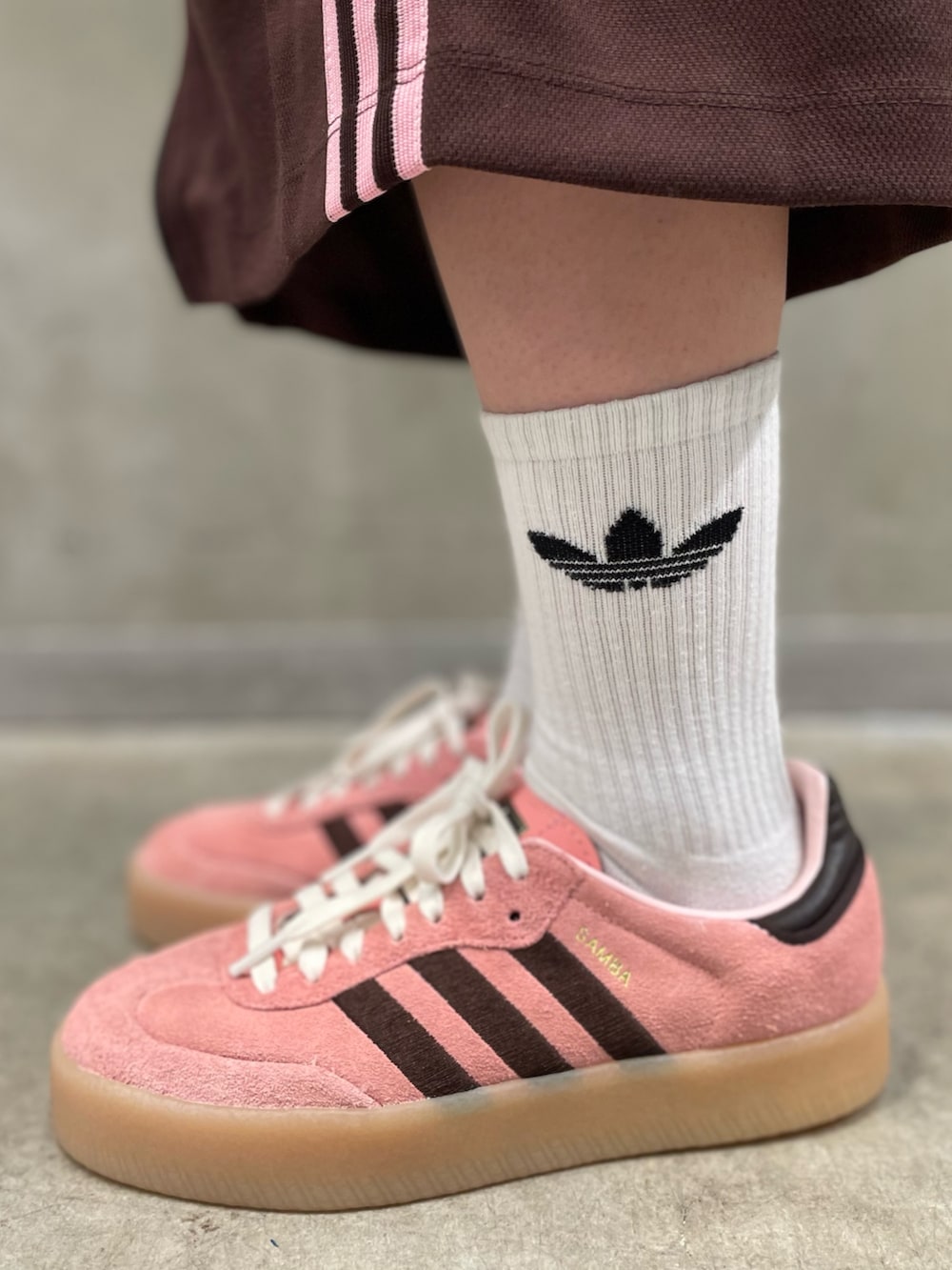 ピンク系のスニーカー、ブラウン系のスカート、ブラウン系のジャージを着用したレディースの秋コーディネートの5枚目の写真