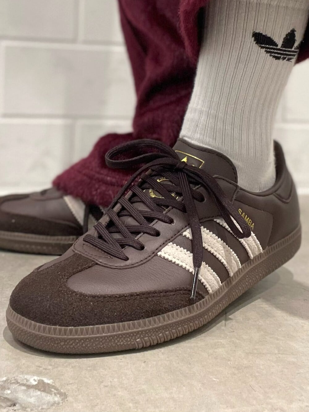 ブルー系のデニムジャケット、ベージュ系のショルダーバッグ、レッド系のスウェットパンツを着用したレディースの秋コーディネートの6枚目の写真