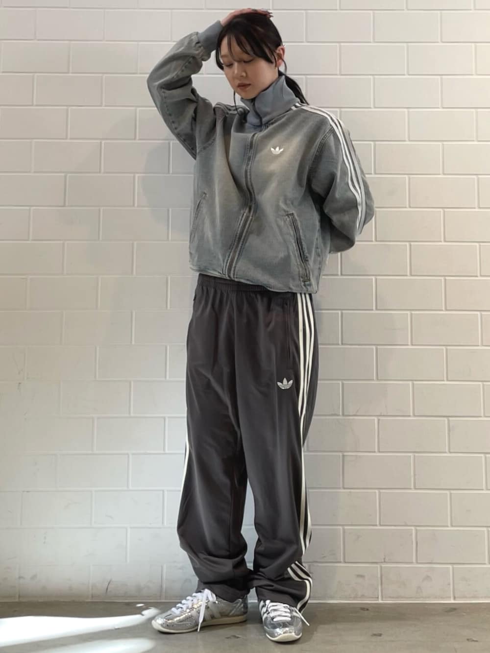 シルバー系のスニーカー、ブルー系のデニムジャケット、グレー系のその他パンツを着用したレディースの春コーディネートの3枚目の写真