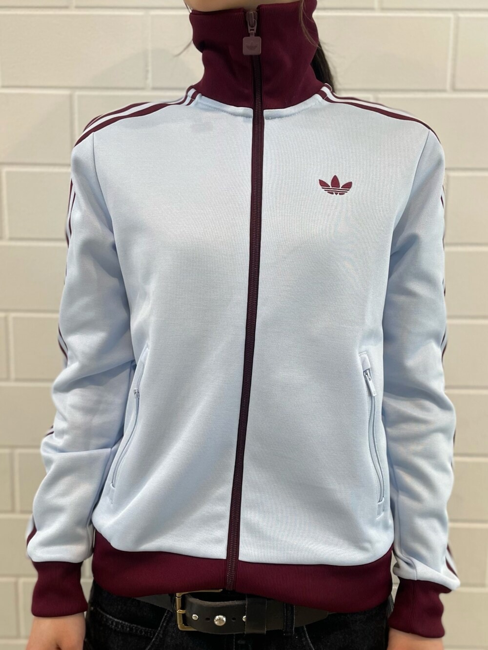 ブルー系のトップス、ブラック系のデニムパンツ、レッド系のシューズを着用したレディースの春コーディネートの4枚目の写真