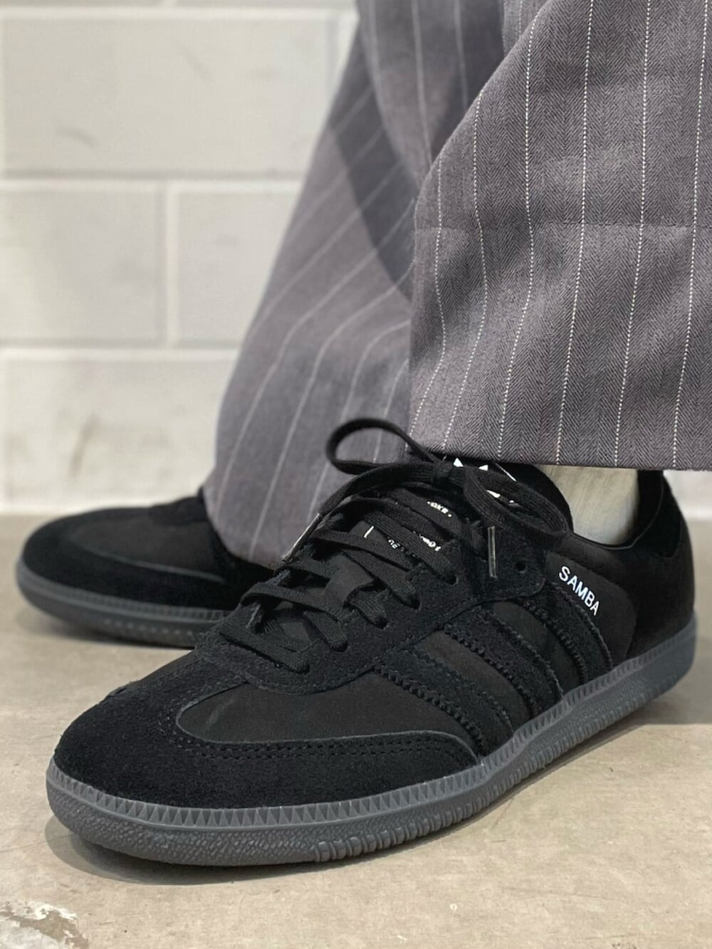 ブラック系のスニーカー、ベージュ系のトップス、ベージュ系のショルダーバッグを着用したレディースの春コーディネートの6枚目の写真