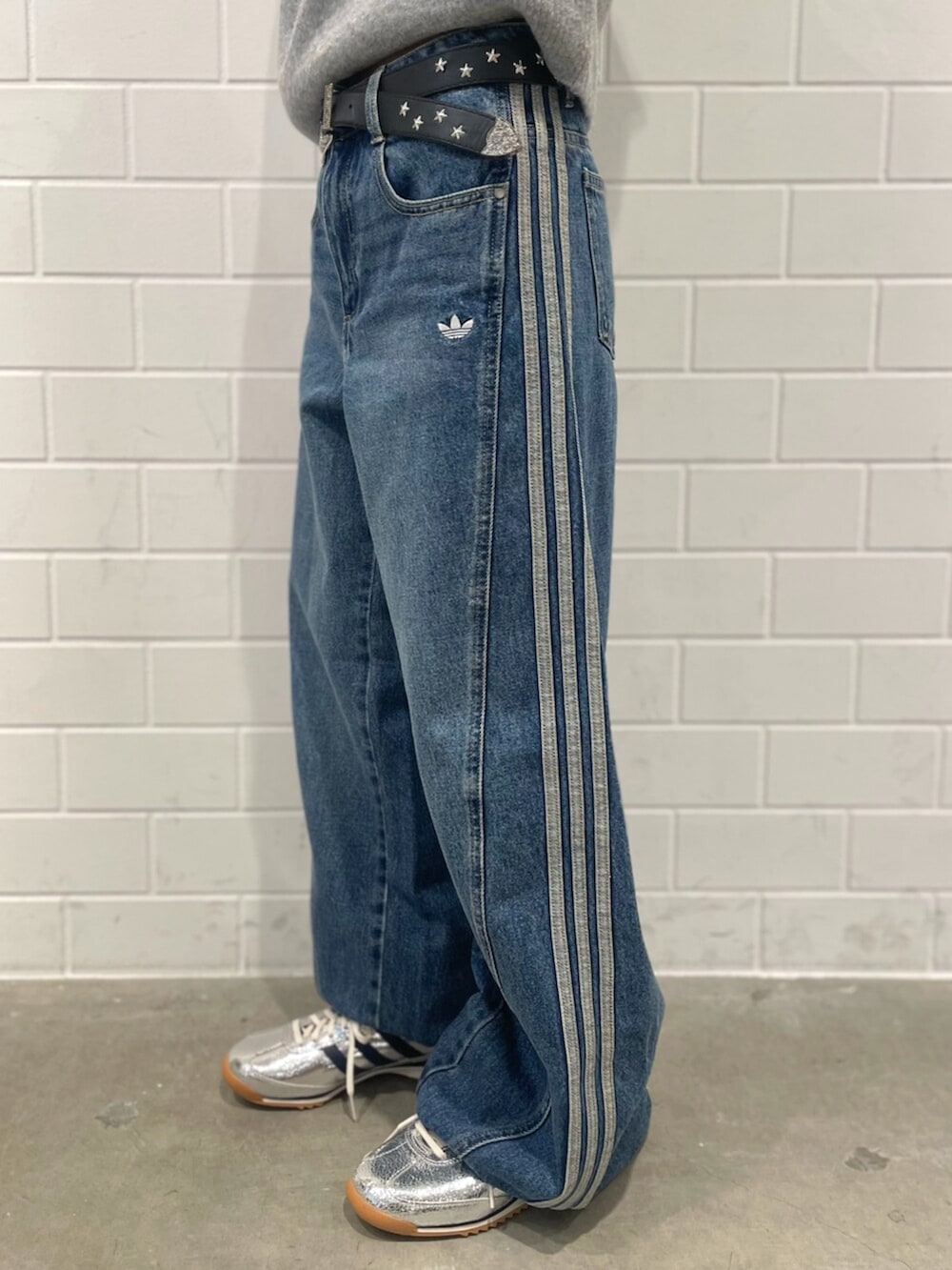 シルバー系のスニーカー、ブルー系のデニムパンツ、グレー系のニット/セーターを着用したレディースの秋コーディネートの5枚目の写真