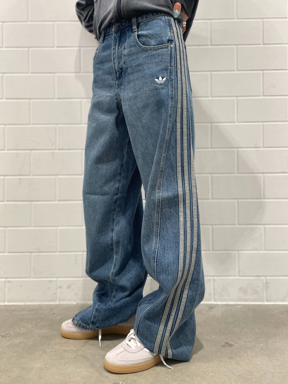 ブラック系のショルダーバッグ、グレー系のスニーカー、ブルー系のパンツを着用したレディースの秋コーディネートの5枚目の写真