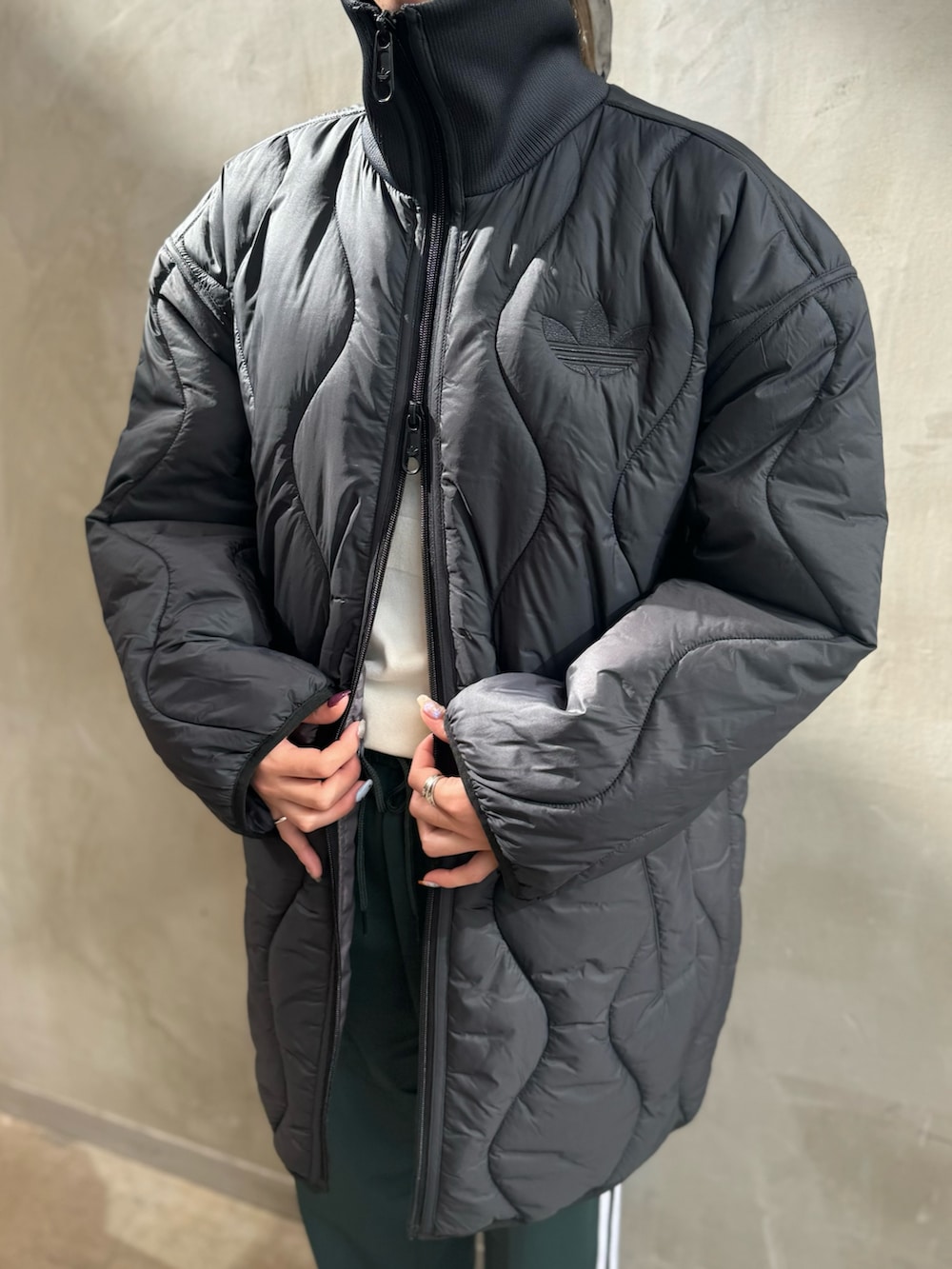 ブラック系のダウンジャケット/コート、ホワイト系のポロシャツ、グリーン系のスウェットパンツを着用したレディースの秋コーディネートの5枚目の写真