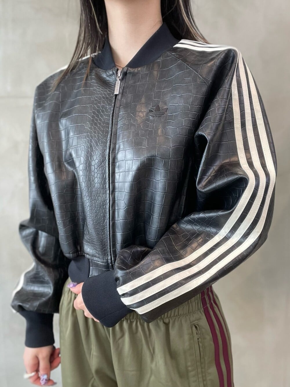 ブラック系のスニーカー、ブラック系のブルゾン、ホワイト系のトップスを着用したレディースの春コーディネートの3枚目の写真