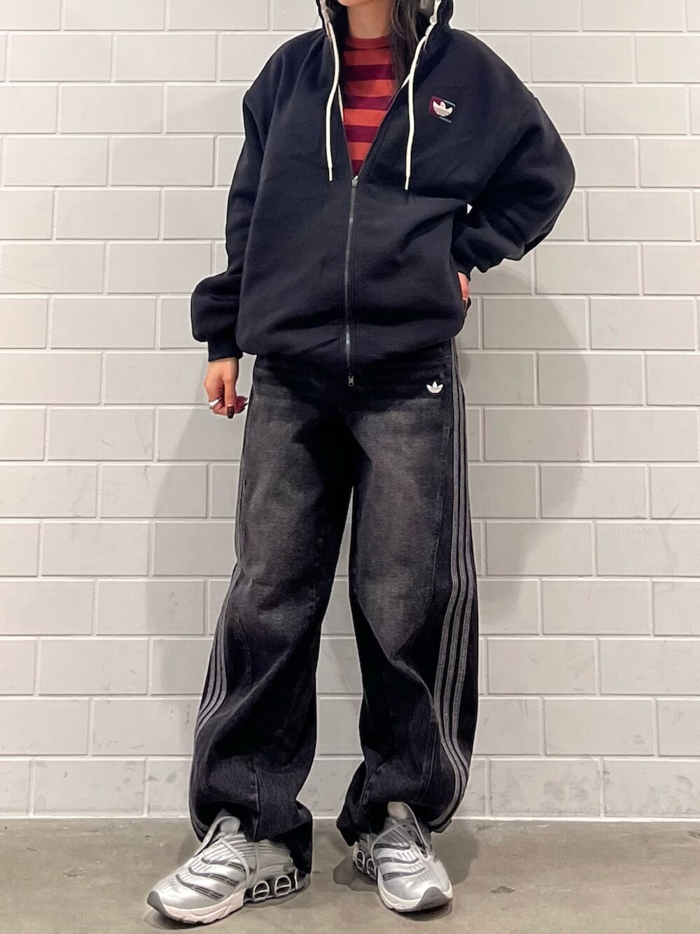 グレー系のシューズ、ブラック系のデニムパンツ、ベージュ系のブルゾンを着用したレディースの秋コーディネートの2枚目の写真