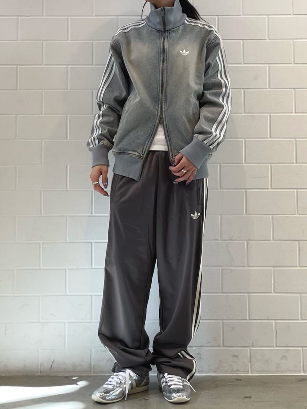 シルバー系のスニーカー、ブルー系のデニムジャケット、グレー系のその他パンツを着用したレディースの春コーディネートの2枚目の写真