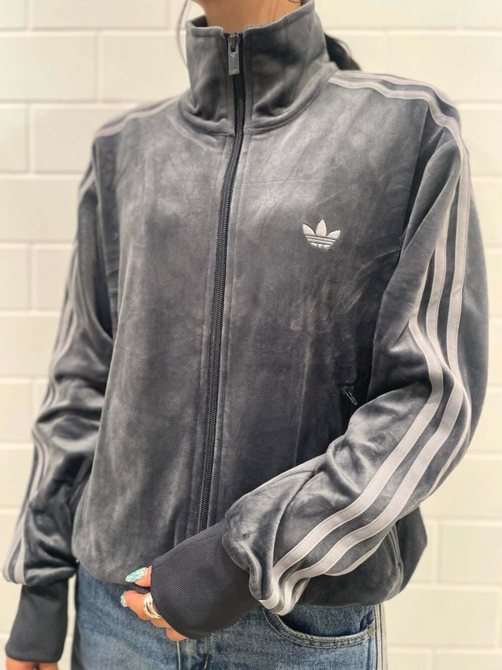 ブラック系のショルダーバッグ、グレー系のスニーカー、ブルー系のパンツを着用したレディースの秋コーディネートの3枚目の写真