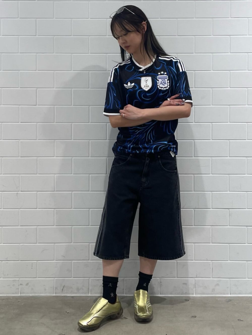 ゴールド系のシューズ、ブラック系のTシャツ/カットソー、ブラック系のデニムパンツを着用したレディースの春コーディネートの3枚目の写真