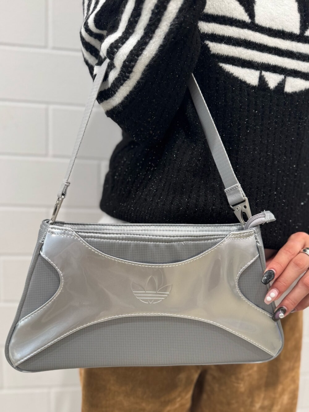 シルバー系のショルダーバッグ、ブラック系のスウェット、ブラウン系のその他パンツを着用したレディースの秋コーディネートの4枚目の写真