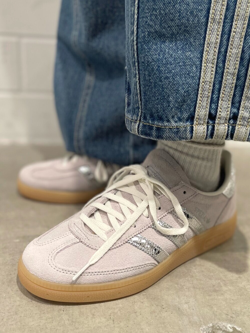 ブラック系のショルダーバッグ、グレー系のスニーカー、ブルー系のパンツを着用したレディースの秋コーディネートの6枚目の写真