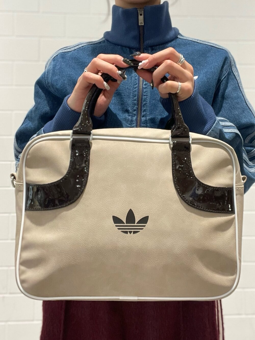 ブルー系のデニムジャケット、ベージュ系のショルダーバッグ、レッド系のスウェットパンツを着用したレディースの秋コーディネートの4枚目の写真