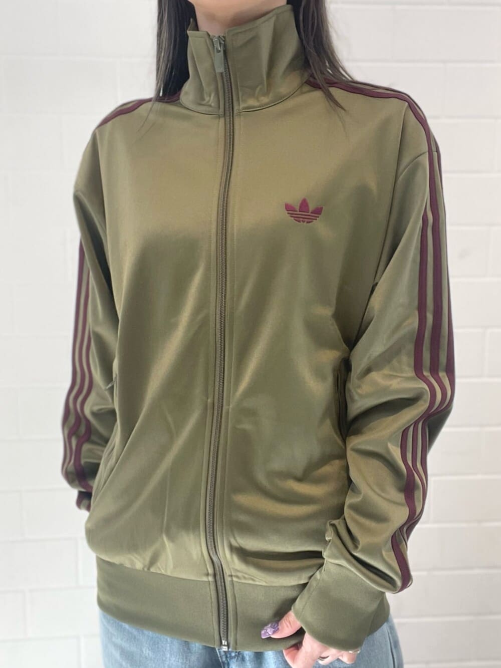 レッド系のスニーカー、グリーン系のジャージを着用したレディースの春コーディネートの3枚目の写真