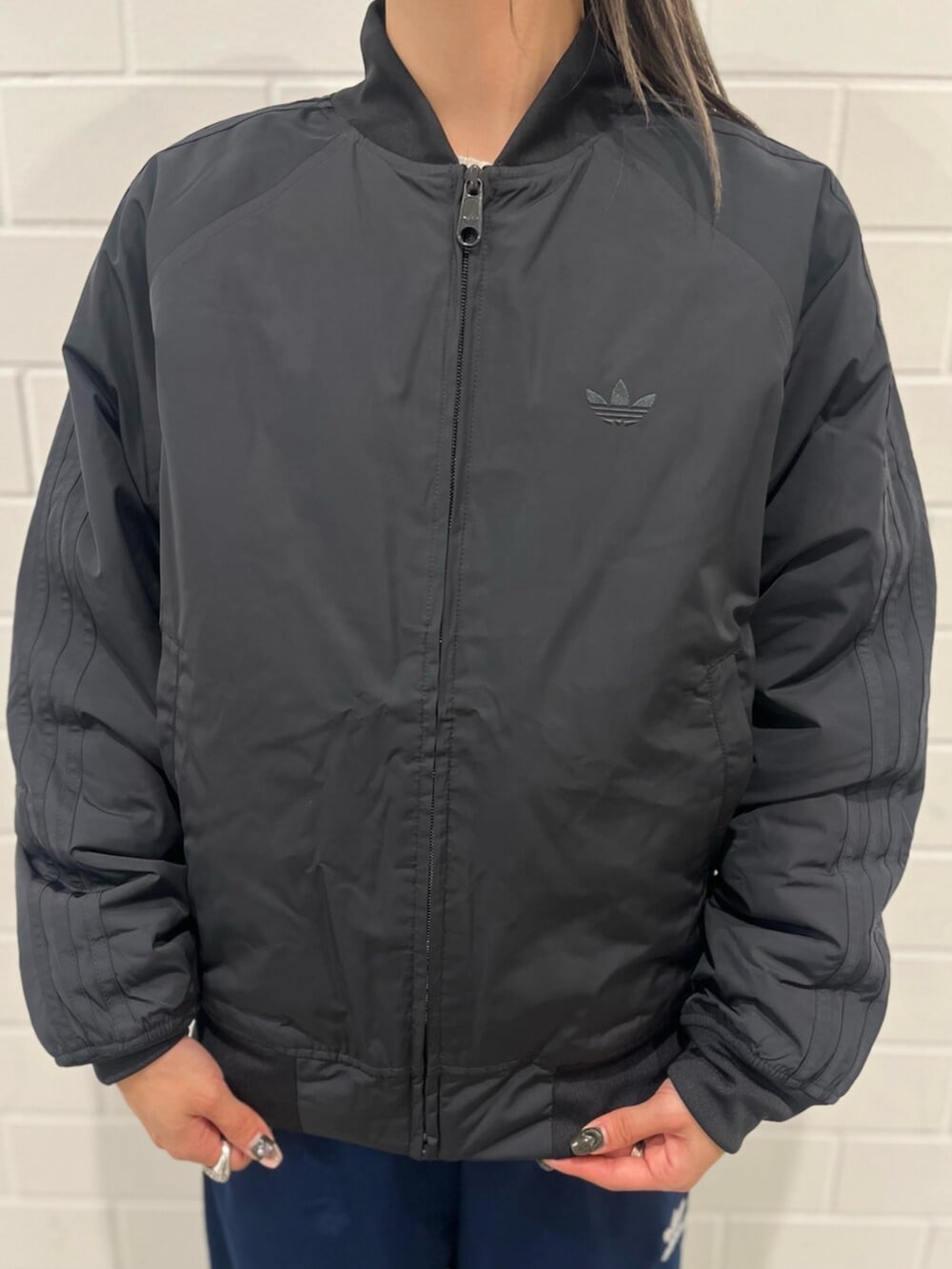 ブルー系のスウェットパンツ、ブラック系のブルゾン、ブラック系のスニーカーを着用したレディースの秋コーディネートの5枚目の写真