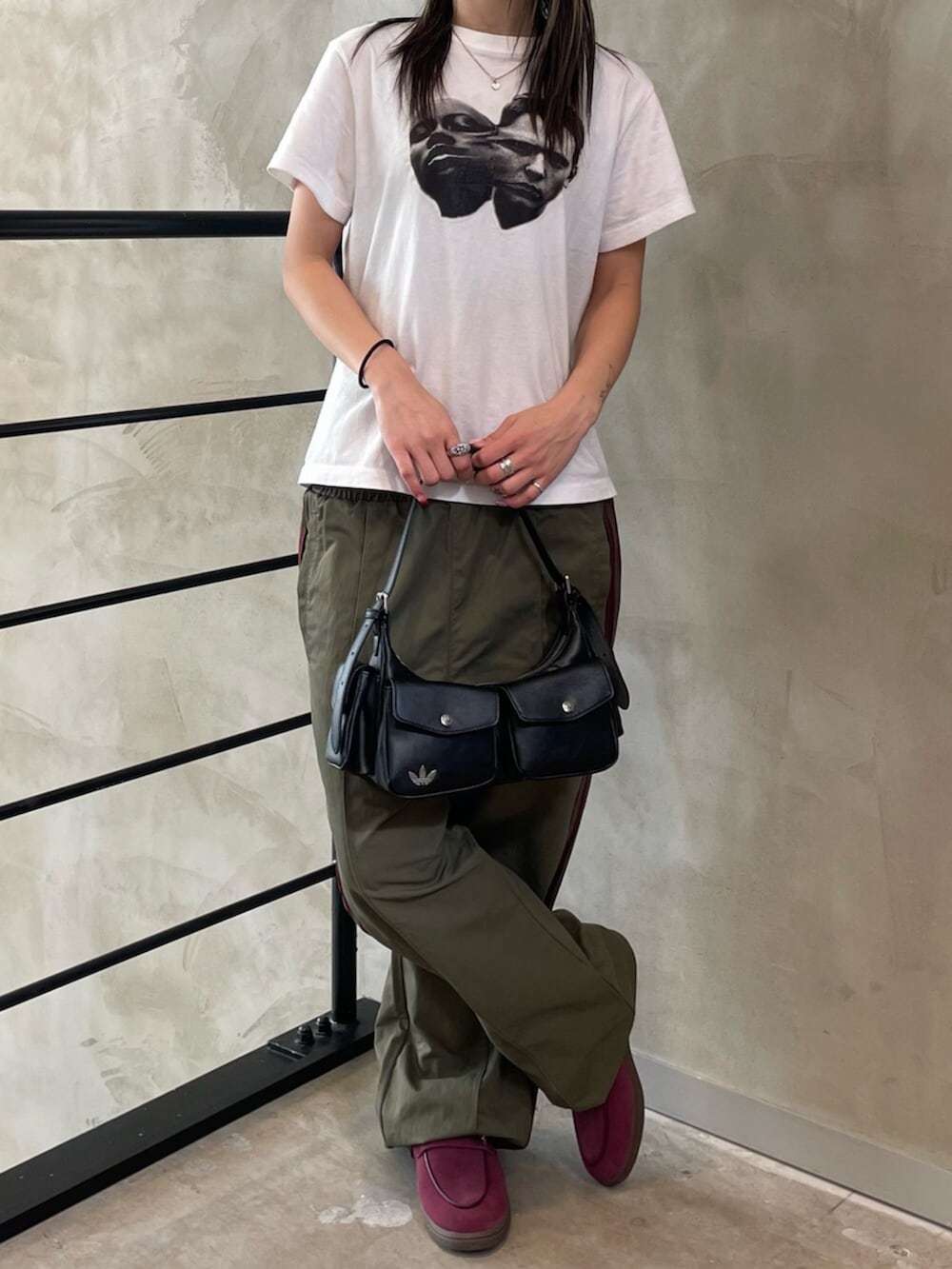 ブラック系のショルダーバッグ、レッド系のスニーカー、グリーン系のその他パンツを着用したレディースの春コーディネートの2枚目の写真