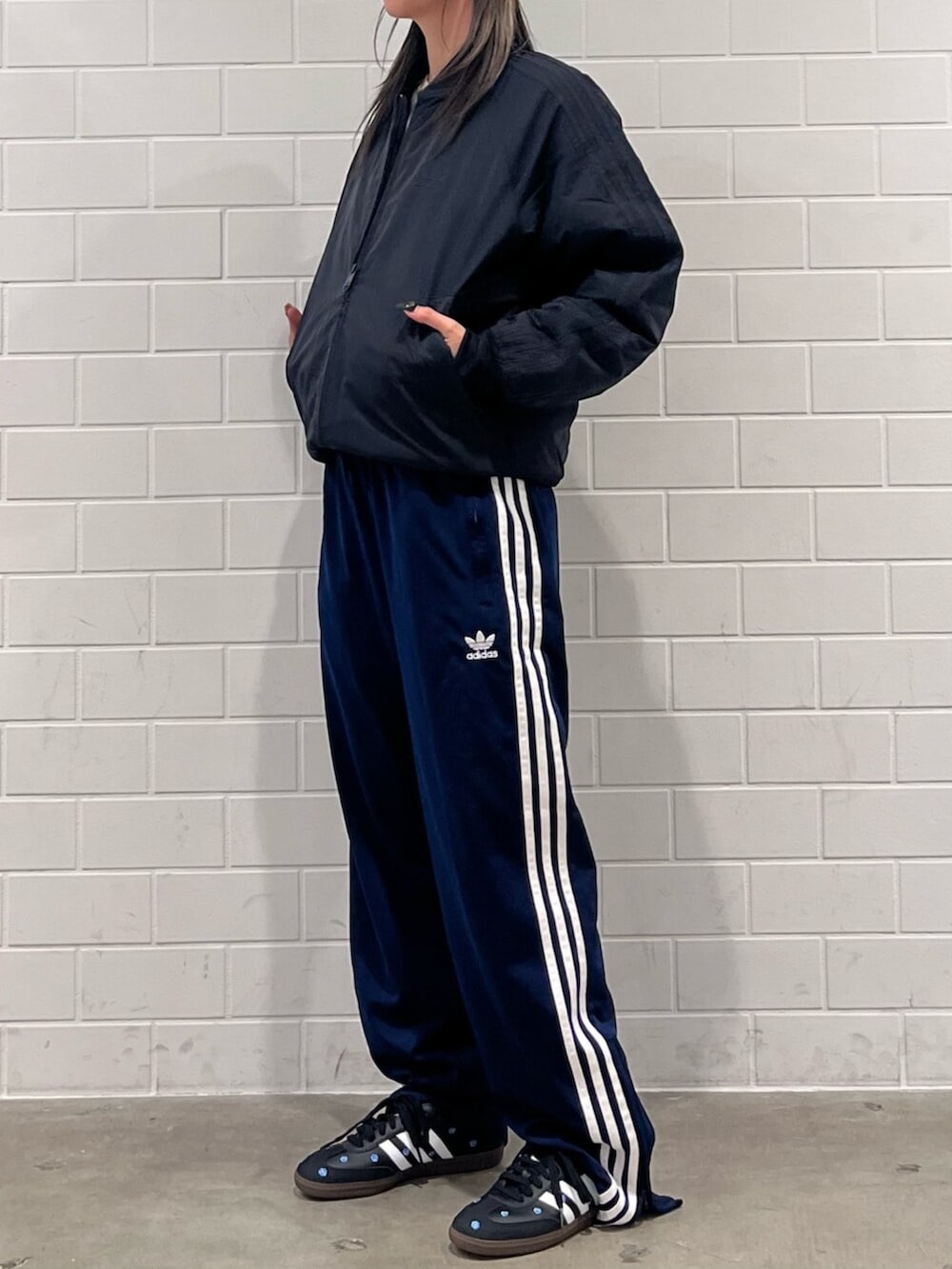 ブルー系のスウェットパンツ、ブラック系のブルゾン、ブラック系のスニーカーを着用したレディースの秋コーディネートの2枚目の写真