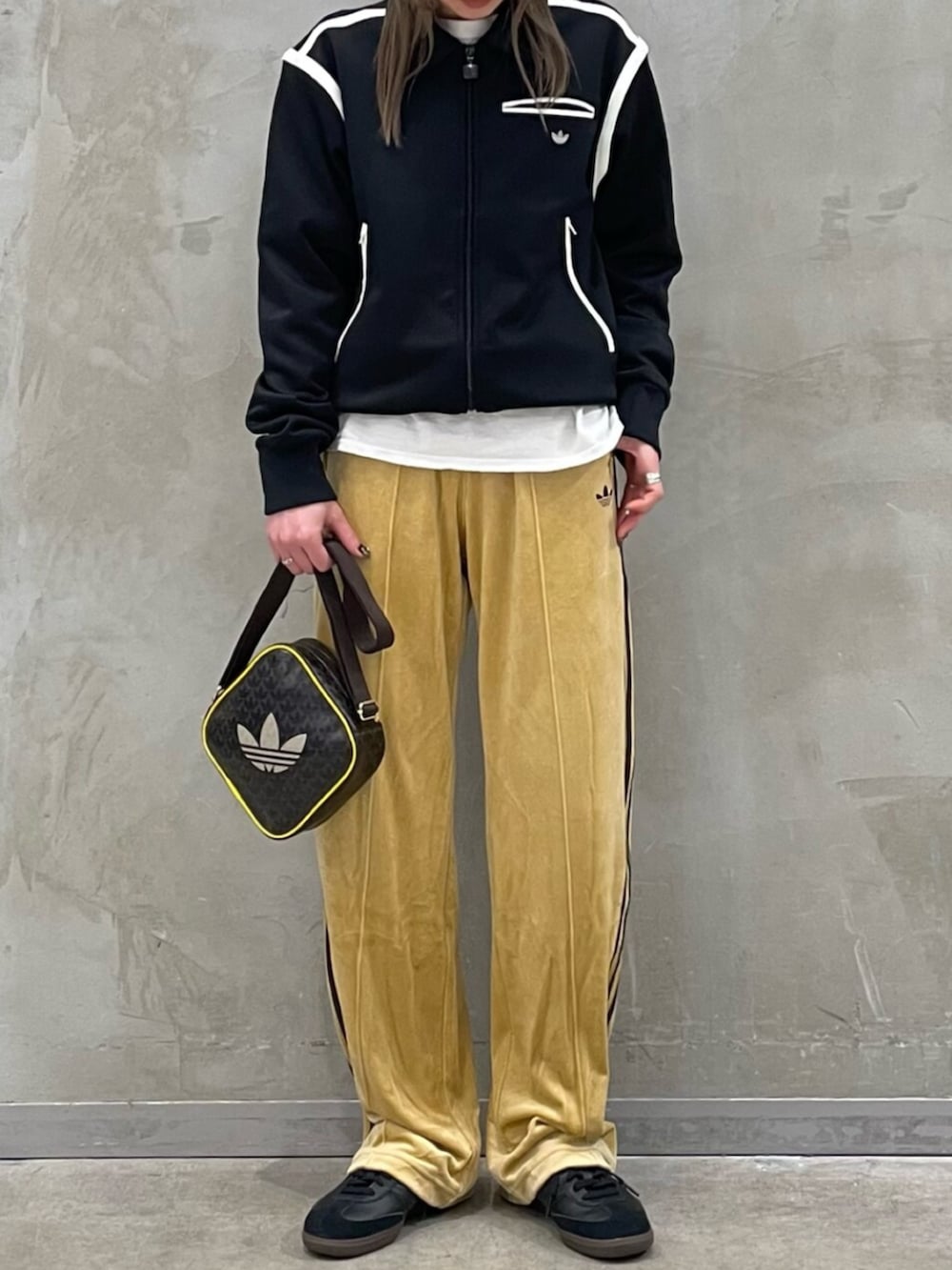 ブラック系のナイロンジャケット、ベージュ系のその他パンツ、ブラック系のスニーカーを着用したレディースの冬コーディネートの2枚目の写真