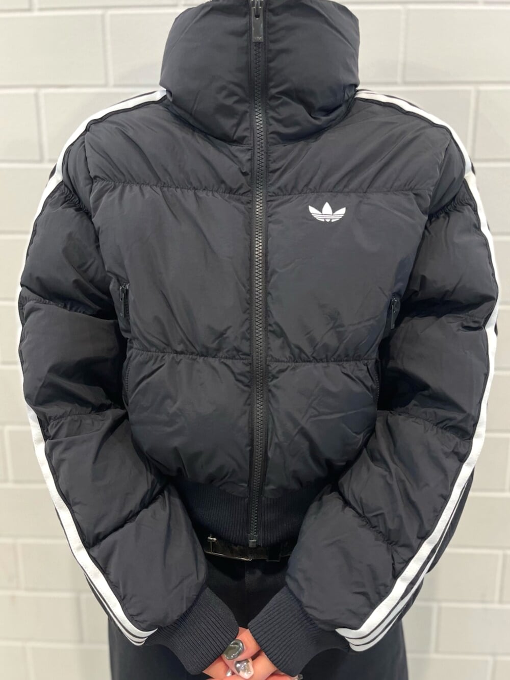 ホワイト系のTシャツ/カットソー、ブラック系のスニーカー、ブラック系のダウンジャケット/コートを着用したレディースの秋コーディネートの4枚目の写真