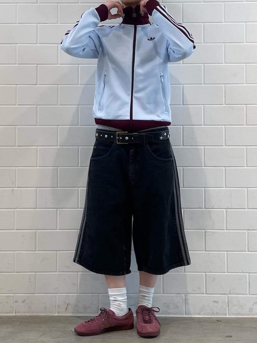 ブルー系のトップス、ブラック系のデニムパンツ、レッド系のシューズを着用したレディースの春コーディネートの2枚目の写真