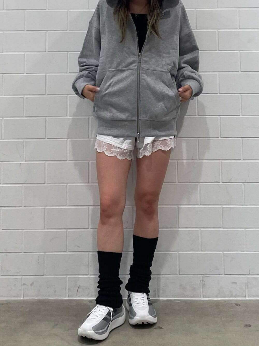 ホワイト系のその他パンツ、グレー系のパーカー、ブラック系のスニーカーを着用したレディースの秋コーディネートの2枚目の写真