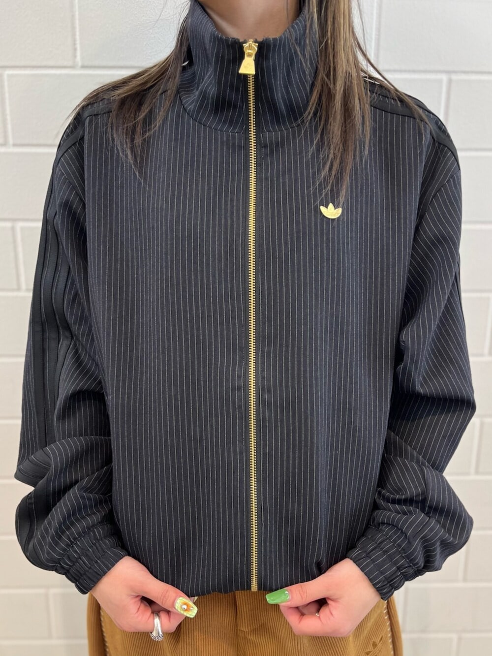 ブラック系のショルダーバッグ、ブラック系のジャージ、ブラック系のスニーカーを着用したレディースの冬コーディネートの3枚目の写真