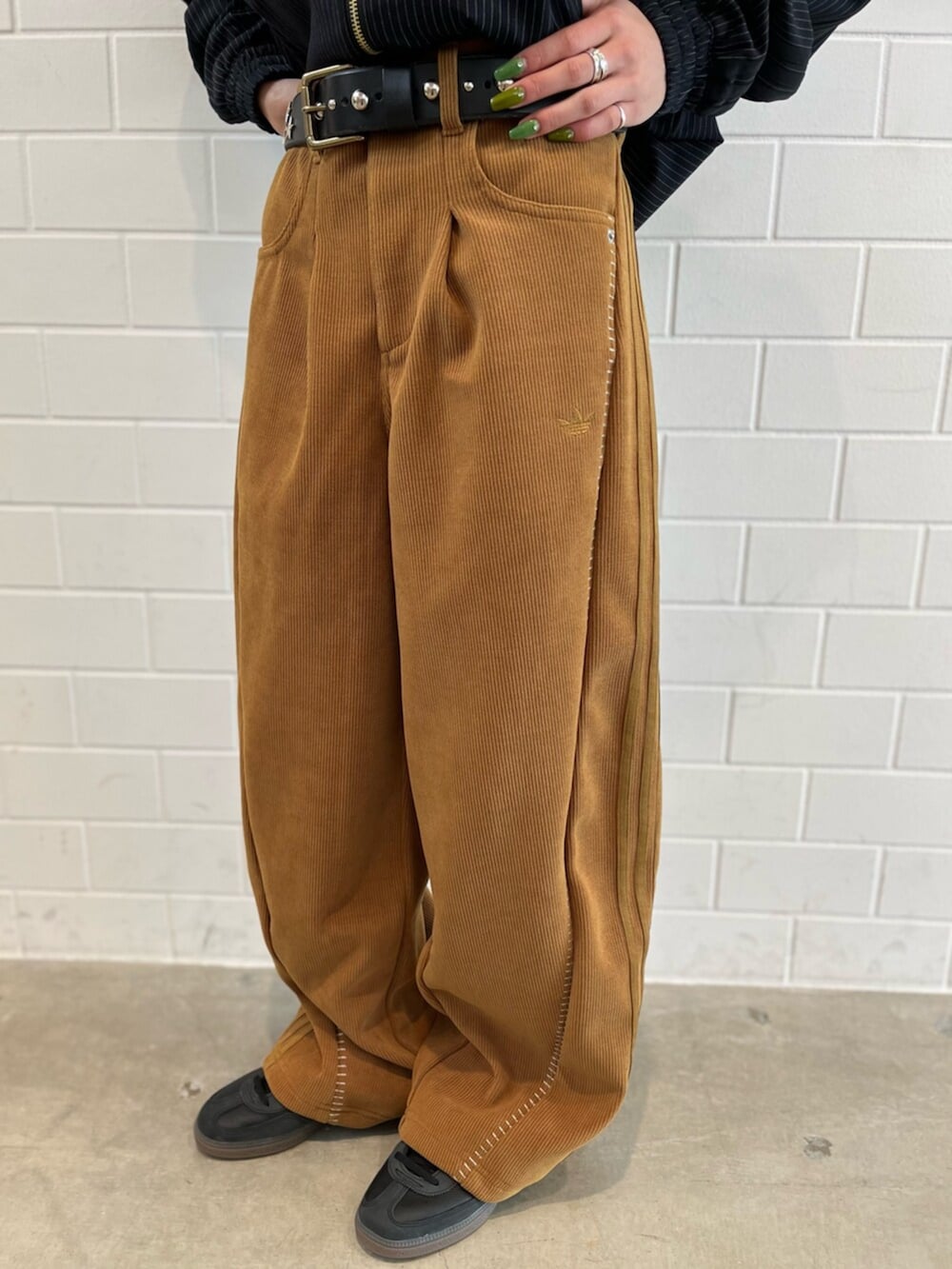 ブラック系のショルダーバッグ、ブラック系のジャージ、ブラック系のスニーカーを着用したレディースの冬コーディネートの5枚目の写真