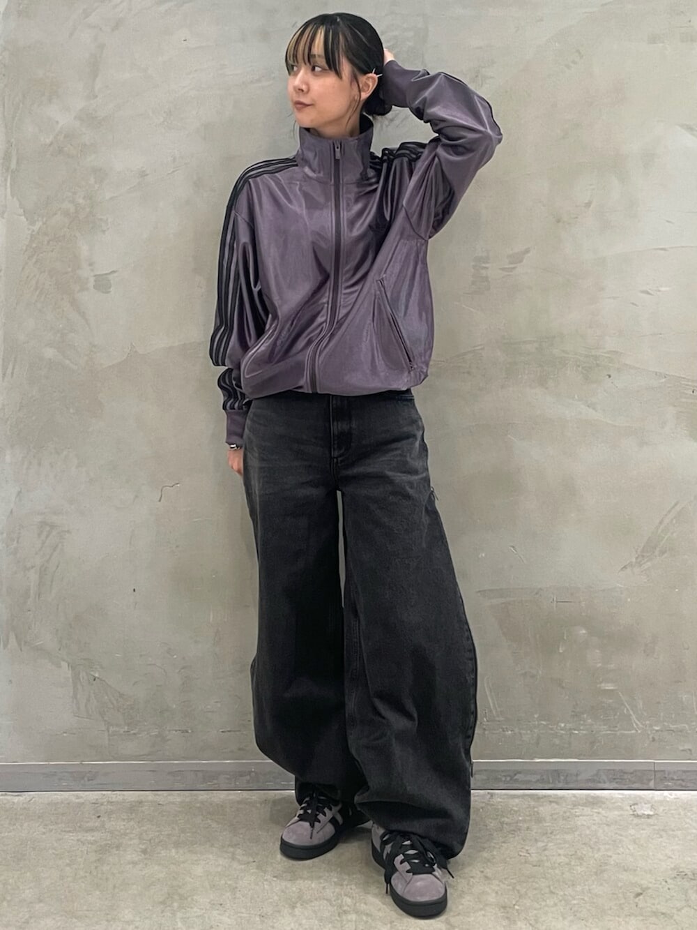 ブラウン系のスニーカー、グレー系のトップス、ブラック系のデニムパンツを着用したレディースの秋コーディネートの3枚目の写真