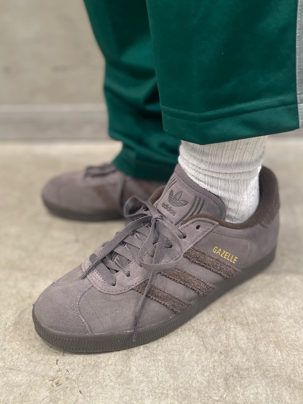 ブラウン系のジャケット/アウター、ホワイト系のニット/セーター、グレー系のスニーカーを着用したレディースの冬コーディネートの6枚目の写真