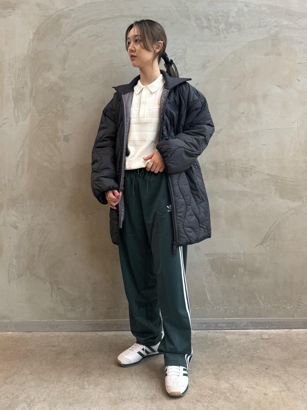 ブラック系のダウンジャケット/コート、ホワイト系のポロシャツ、グリーン系のスウェットパンツを着用したレディースの秋コーディネートの3枚目の写真