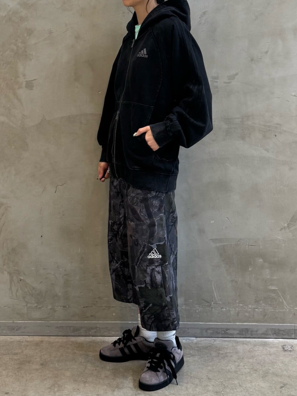 ブラック系のパーカー、ブラック系のその他パンツ、ブラウン系のスニーカーを着用したレディースの夏コーディネートの2枚目の写真