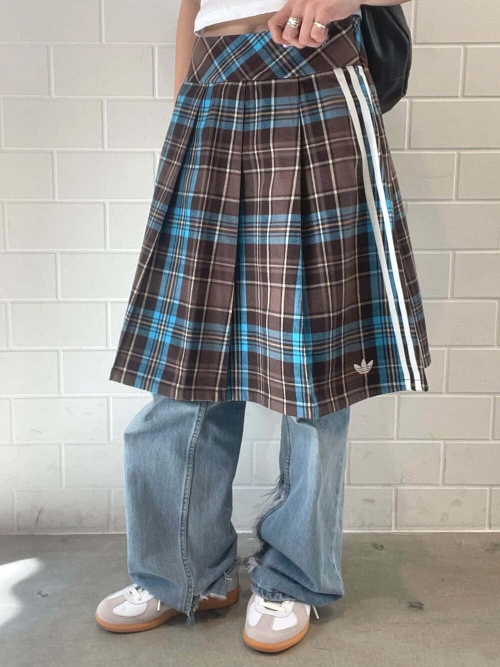 ブラウン系のスカート、ブラウン系のショルダーバッグ、ホワイト系のシューズを着用したレディースの春コーディネートの5枚目の写真