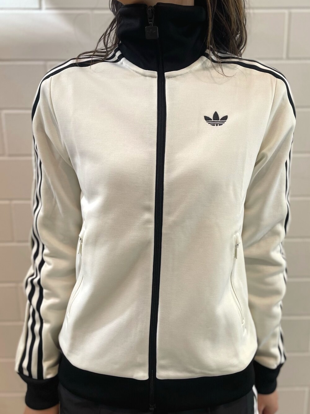 ブラック系のショルダーバッグ、ブラック系のスニーカー、ホワイト系のトップスを着用したレディースの春コーディネートの3枚目の写真