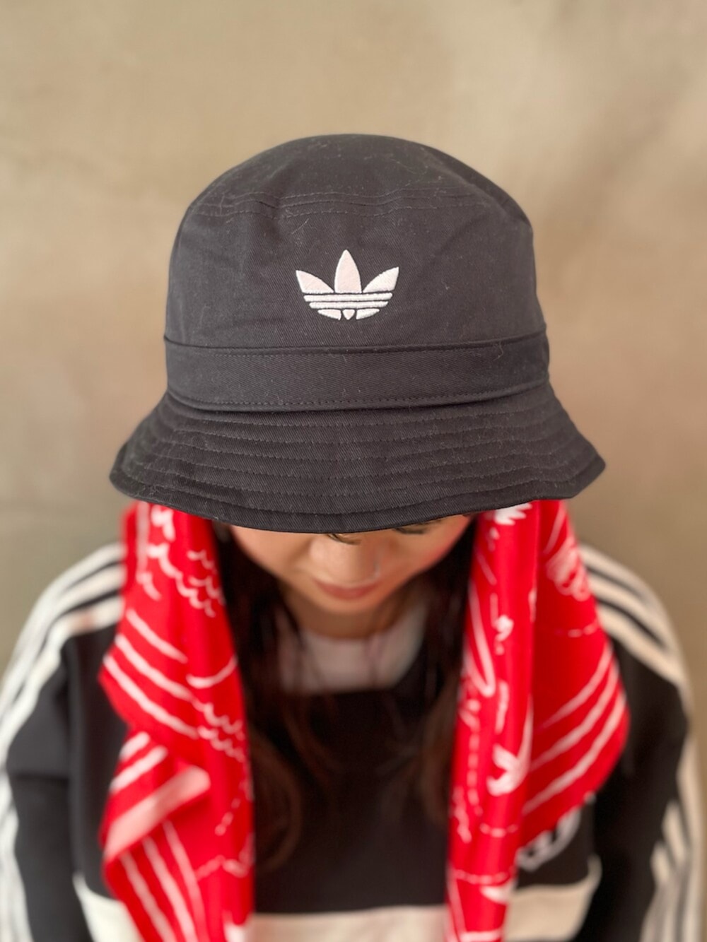 レッド系のスニーカー、ブラック系のトップス、ブラック系のハットを着用したレディースの春コーディネートの3枚目の写真