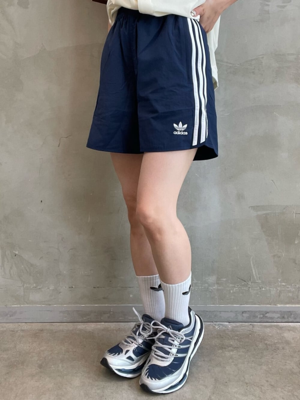 ベージュ系のトップス、ブルー系のスウェットパンツ、ブルー系のスニーカーを着用したレディースの夏コーディネートの5枚目の写真