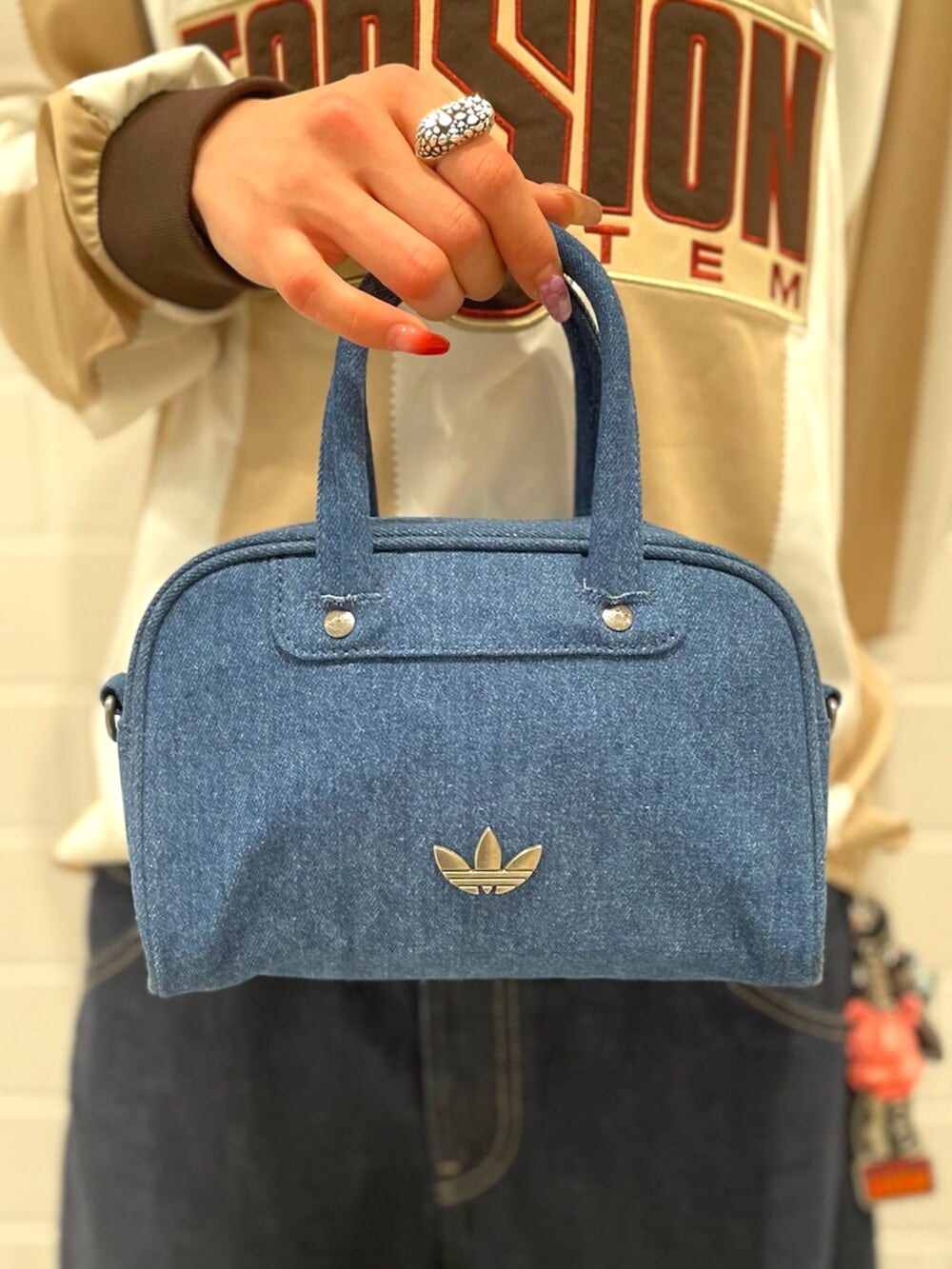 ホワイト系のTシャツ/カットソー、ブラウン系のスニーカー、ブルー系のショルダーバッグを着用したレディースの春コーディネートの5枚目の写真