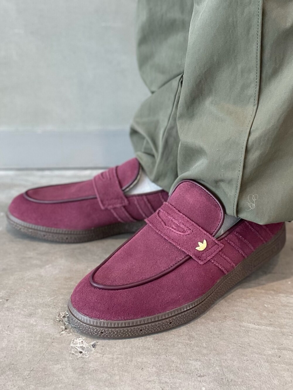 ブラック系のショルダーバッグ、レッド系のスニーカー、グリーン系のその他パンツを着用したレディースの春コーディネートの6枚目の写真