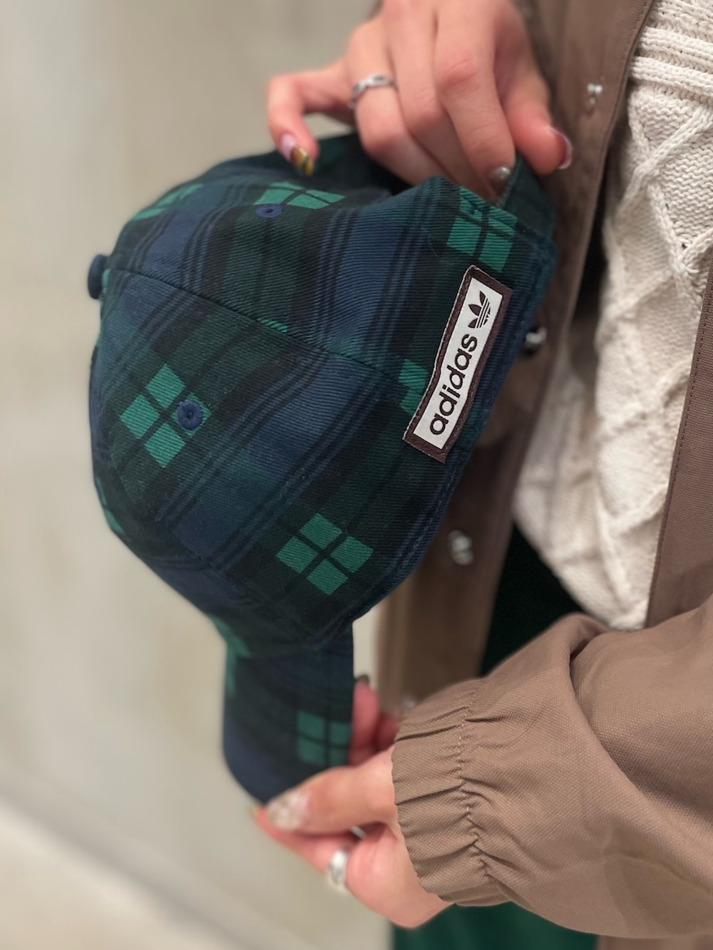 ブラウン系のジャケット/アウター、ホワイト系のニット/セーター、グレー系のスニーカーを着用したレディースの冬コーディネートの3枚目の写真