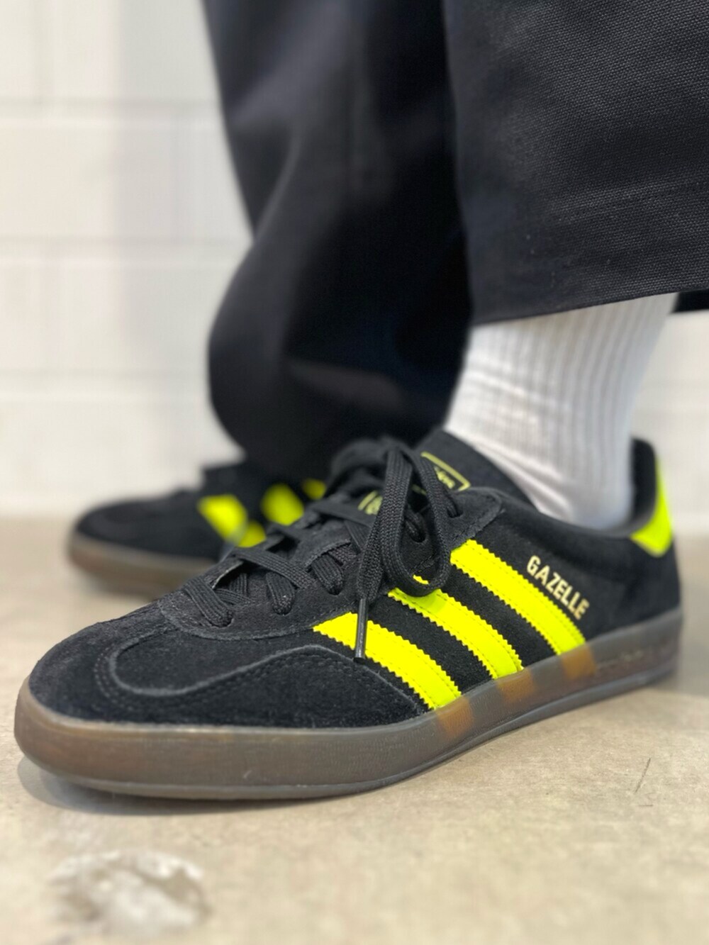 ホワイト系のTシャツ/カットソー、ブラック系のスニーカー、ブラック系のダウンジャケット/コートを着用したレディースの秋コーディネートの6枚目の写真