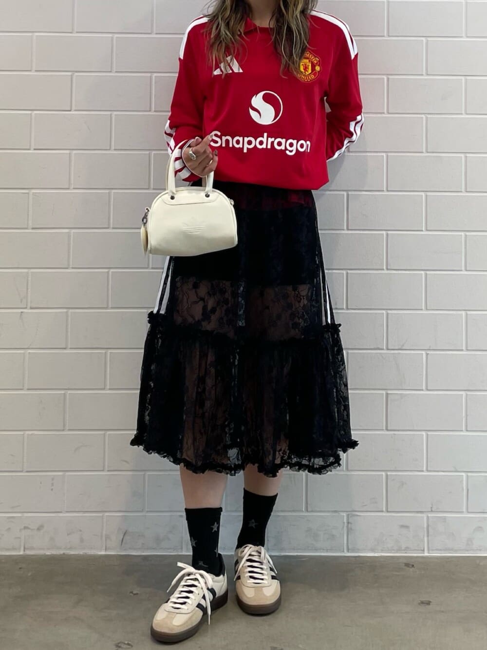 ホワイト系のスニーカー、レッド系のTシャツ/カットソー、ホワイト系のハンドバッグを着用したレディースの秋コーディネートの2枚目の写真